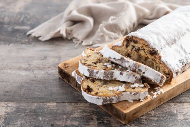 Geleneksel Noel Stollen, kuru üzüm ve pudra şekeriyle ahşap masada. Boşluğu kopyala