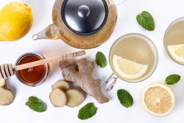Beyaz arka planda izole edilmiş bal ve limonlu zencefil çayı.