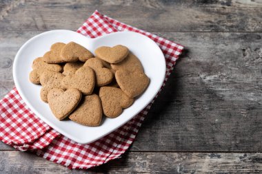 Tahta masada kalp şeklinde zencefilli kurabiye. Boşluğu kopyala