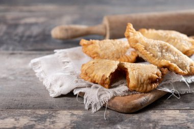 Ahşap masada ev yapımı balkabağı börekleri. Boşluğu kopyala