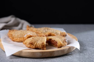 Gri taşlı arka planda ev yapımı tatlı balkabağı börekleri. Boşluğu kopyala