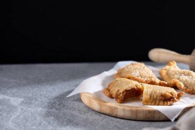 Gri taşlı arka planda ev yapımı tatlı balkabağı börekleri. Boşluğu kopyala