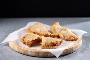 Gri taşlı arka planda ev yapımı tatlı balkabağı empanadillası