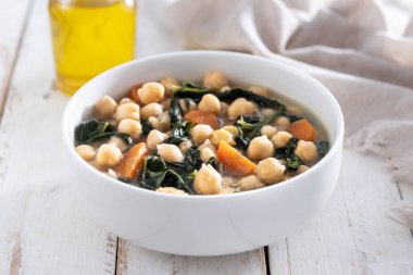 Tahta masadaki havuçlu nohut ve ıspanak çorbası.