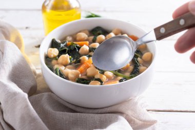 Tahta masadaki havuçlu nohut ve ıspanak çorbası.