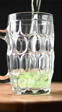 Aziz Patrick Günü için köpüklü yeşil bira bardağı dolduruyorum.