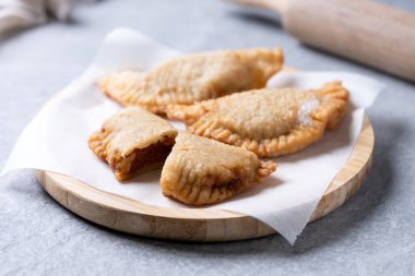 Gri taşlı arka planda ev yapımı tatlı balkabağı empanadillası