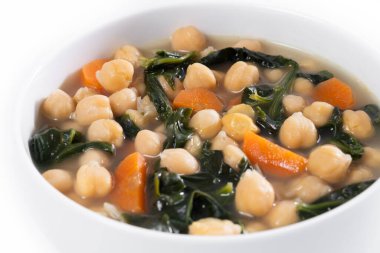 Beyaz mermer üzerinde izole edilmiş havuçlu nohut ve ıspanak çorbası. Kapat.