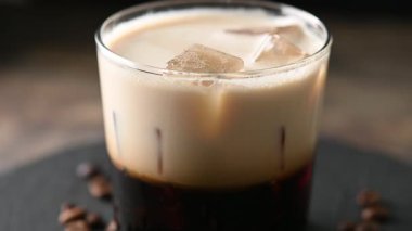 Beyaz Rus Kokteyli 'ni siyah arka planda votka ve kremayla tazeliyorum.
