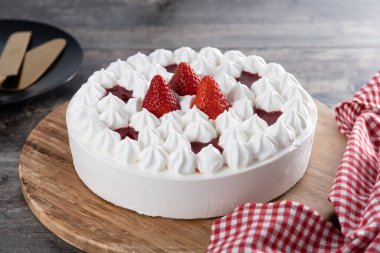 Tahta masadaki kremalı taze çilekli pasta.