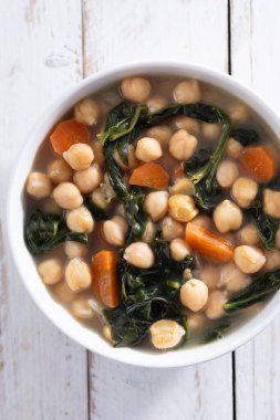 Beyaz arka planda izole edilmiş havuçlu nohut ve ıspanak çorbası.