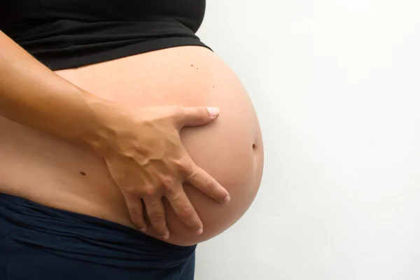 Mulher grávida com um fundo branco — Fotografia de Stock