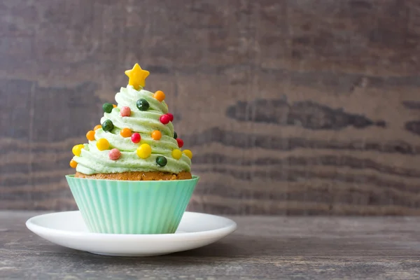 Cupcake with Christmas tree shape on wood — Stock Photo, Image