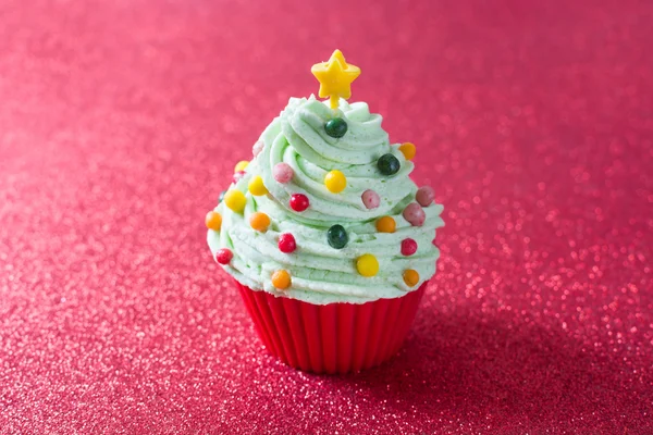 Cupcake de árvore de Natal com um fundo de brilho vermelho — Fotografia de Stock