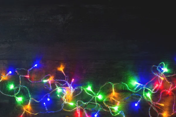 Vánoční osvětlení na dřevo pozadí — Stock fotografie