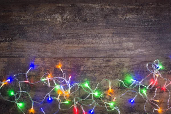 Weihnachtsbeleuchtung auf einem Holz-Hintergrund — Stockfoto