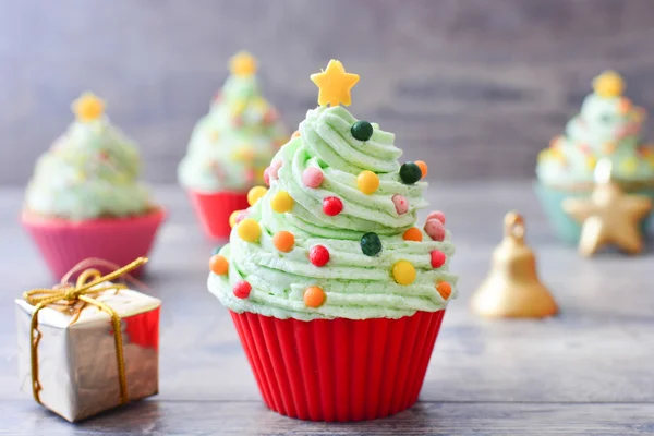 Cupcakes de árvore de Natal em uma mesa de madeira . — Fotografia de Stock