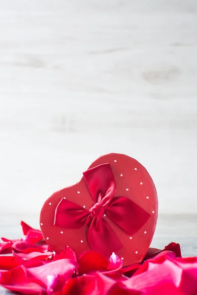 Confezione regalo a forma di cuore e petali — Foto Stock