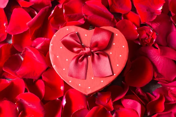 Confezione regalo a forma di cuore e petali — Foto Stock