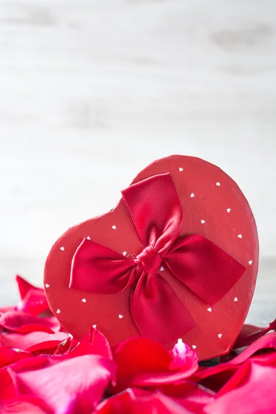 Confezione regalo a forma di cuore e petali — Foto Stock