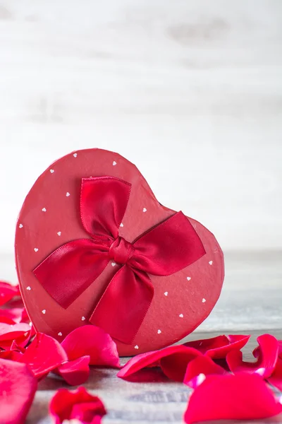 Confezione regalo a forma di cuore e petali — Foto Stock