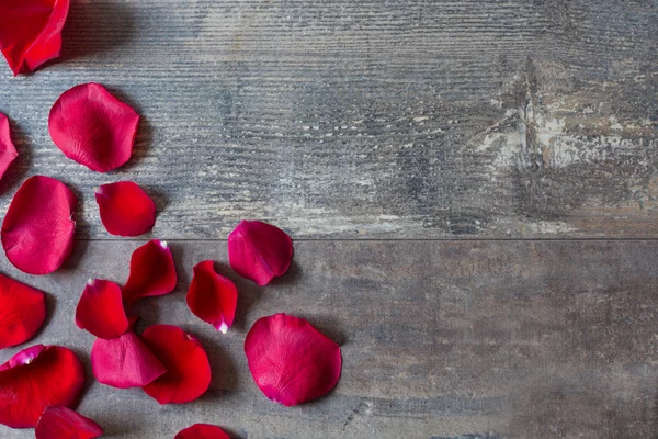 Red petals on wood — Stock Photo, Image