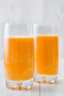 Beyaz ahşap üzerine cam portakal suyu