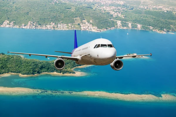 The plane flies over the sea coast — Stock Photo, Image