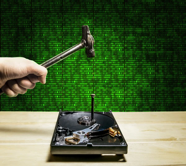 A hammer hits a nail into the hard drive from the computer in th — Stock Photo, Image