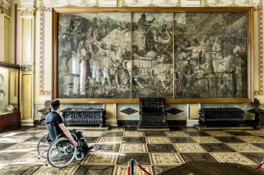 Wheelchair admires the works of art at the State Hermitage Museu clipart