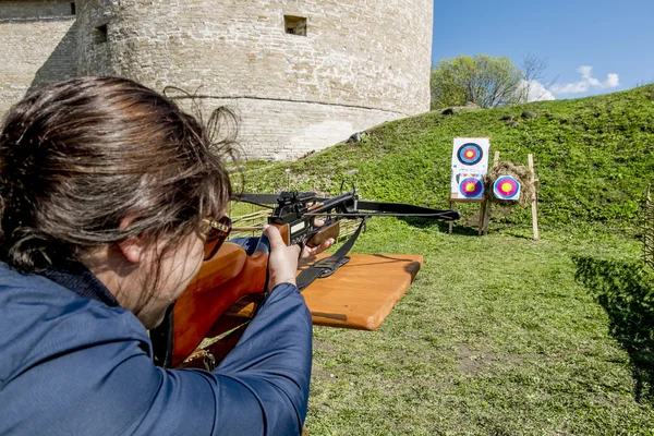 Dívka střílí kuše od hradeb pevnosti v městě Staraya — Stock fotografie