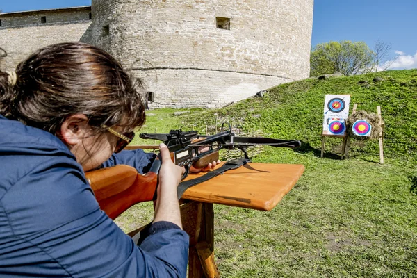 Dívka střílí kuše od hradeb pevnosti v městě Staraya — Stock fotografie