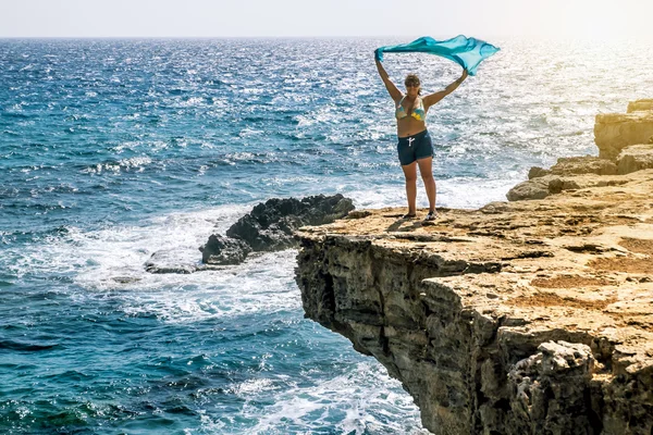 Mujer de pie con agitación en el viento con un pañuelo en th — Foto de Stock