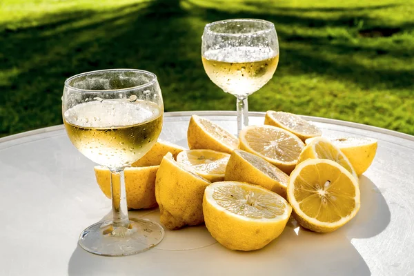 ワイングラスとテーブル上のレモンのカット スライス — ストック写真