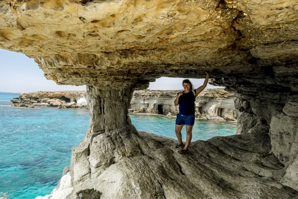 Girl posing in a rocky arch at Cape Greco. — Stock Photo, Image