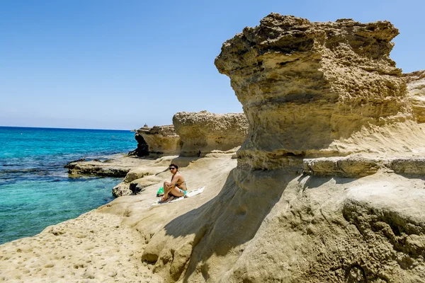 Meisje rustend op het strand tussen de rotsen in Protaras . — Stockfoto