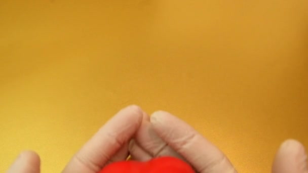Męskie dłonie w rękawiczkach medycznych trzymające czerwone serce zabawki — Wideo stockowe