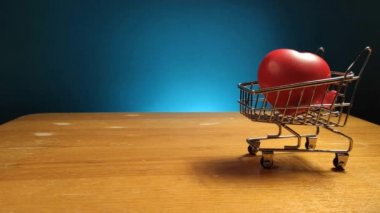 Oyuncak kırmızı kalp alışveriş arabasında.