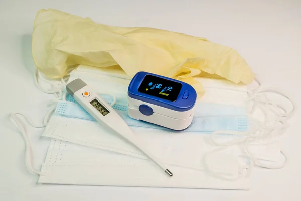 Pulsoximeter Och Termometer Med Medicinska Masker Ljus Bakgrund Medicinsk Utrustning — Stockfoto