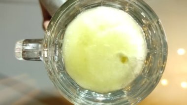 Bira cam masadaki bir bardağa dökülüyor. Alt görünüm.