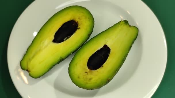 Cuñas de aguacate y cápsulas omega-3 en un plato. — Vídeo de stock