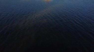 Rusya, Karelia 'da bir gölün ortasındaki taş bir adada güneşlenen bir kız..