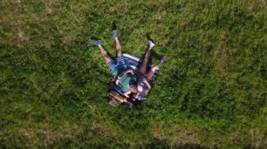 Çimenlerde uzanmış, nazikçe sohbet eden aşıklar.