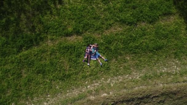 Пара влюбленных, лежащих на траве, нежно болтая — стоковое видео