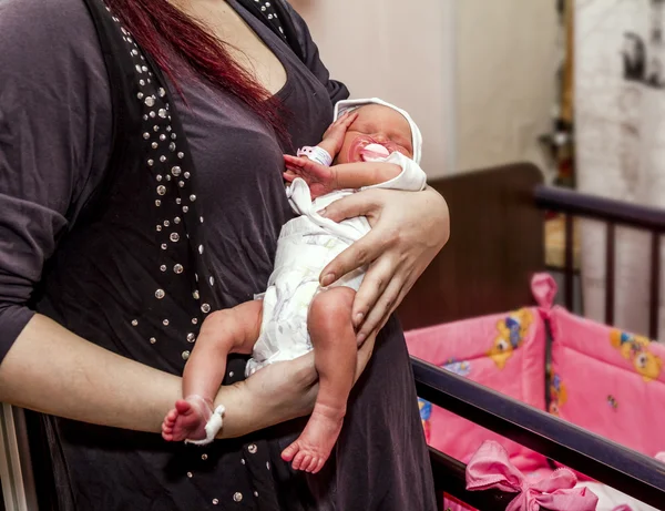 En ung mamma som håller ett nyfött barn — Stockfoto