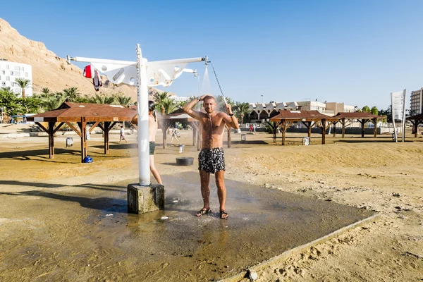 A man is washed in the shower on the beach, dead sea, Israel — Stock Photo, Image