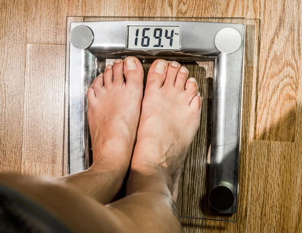 The woman weighed on the scales. — Stock Photo, Image