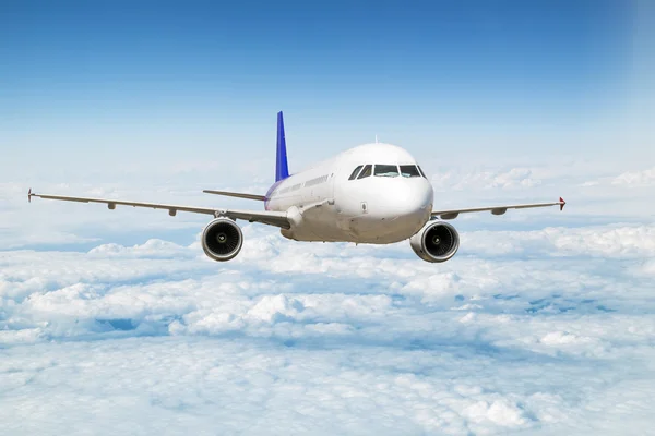 Um avião de passageiros voando acima das nuvens no céu — Fotografia de Stock