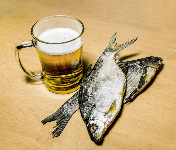 Caneca com cerveja e peixe na mesa — Fotografia de Stock