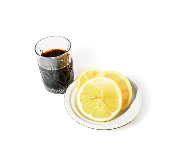 Shot glass with alcohol and lemon on a saucer — 스톡 사진